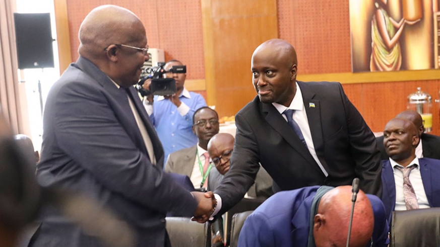 Amb. Olivier Nduhungirehe, Rwanda's Minister of State in charge of the East African Community (right), shakes hands with Ugandan Foreign Affairs minister Sam Kuteesa