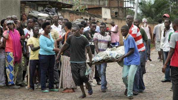 Men carry away a body in the Nyakabiga neighbourhood of Bujumbura, Burundi on Saturday