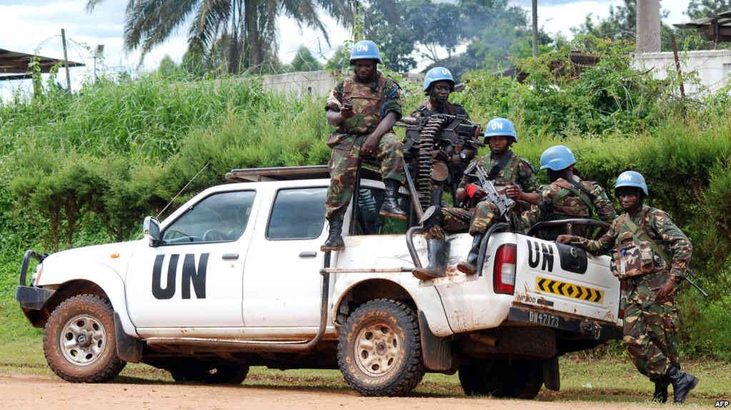 Blue-helmeted members of the U.N. Organization Stabilization Mission in the Democratic Republic of Congo sit on the back of a pickup truck in Beni, Oct. 23, 2014.