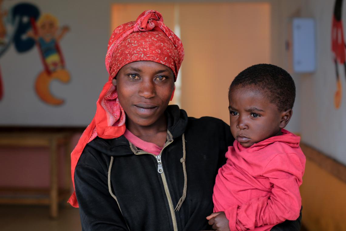 Josiane smiles as she picks her son David up from his day care centre after a day's work on the tea plantation.