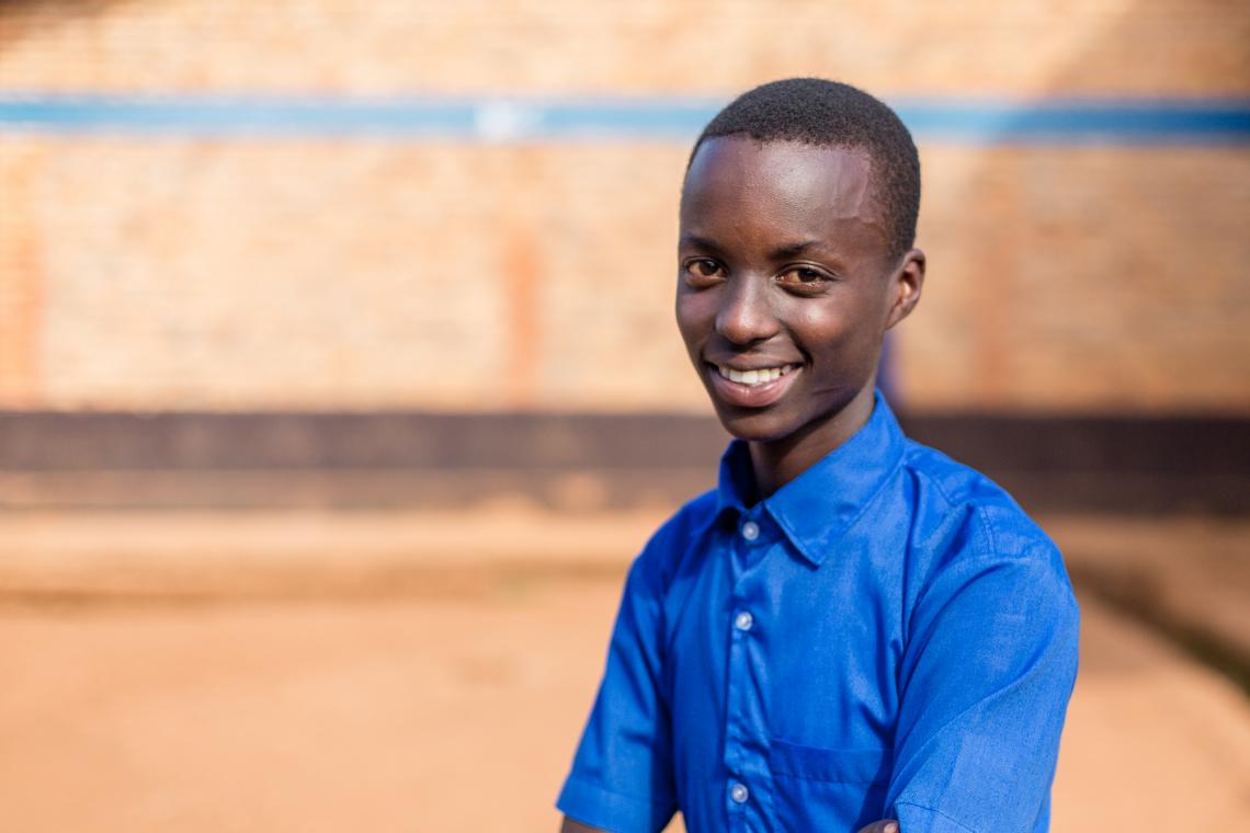 Christian Nsengiyumva stands in the school yard during morning break