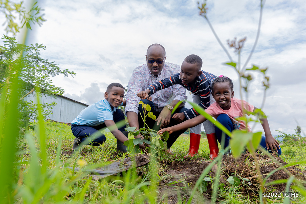 The Mayor of Kigali City, Pudence Rubingisa planting a tree with children from Ecole Belge. 