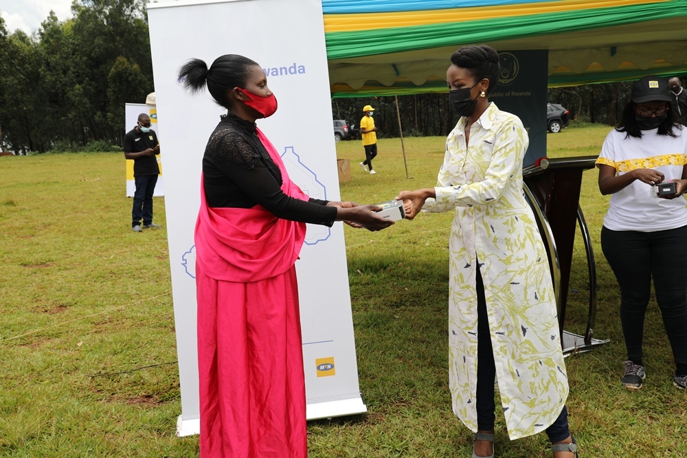 Paula Ingabire,  the Minister of ICT and Innovation handing over a smartphone to one of beneficiaries.