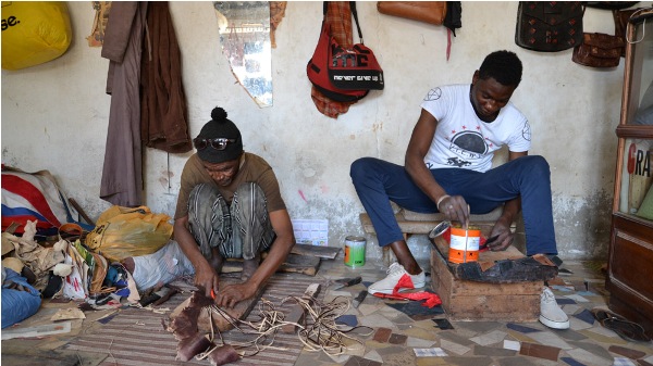 Artisans in Dakar cut details into leather that will eventually be used to make bags