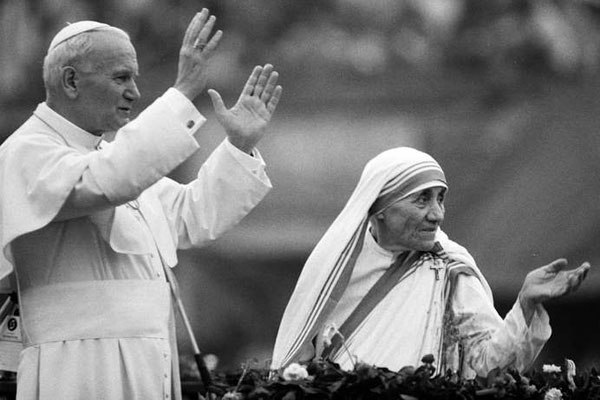 This file photo taken on February 03, 1986 shows Mother Teresa and Pope John Paul II waving to well-wishers, at the Nirmal Hriday Home, in Calcutta.