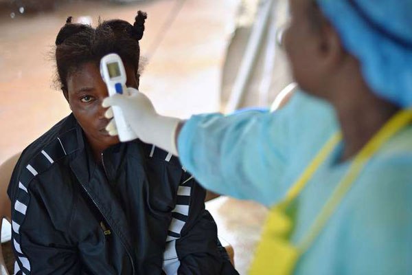 A girl suspected of being infected with the Ebola virus having her temperature checked at the government hospital in Kenema, Sierra Leone, on August 16, 2014.