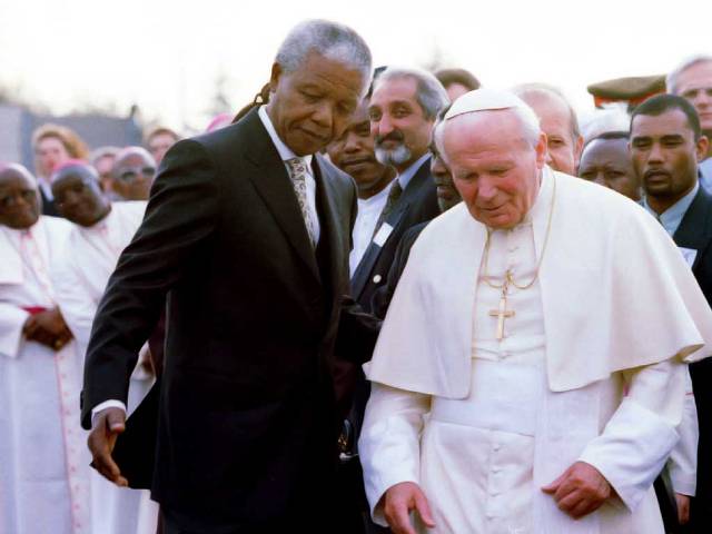 Former South African president Nelson Mandela guides late Pope John Paul II (R) after they met at Johannesburg International Airport