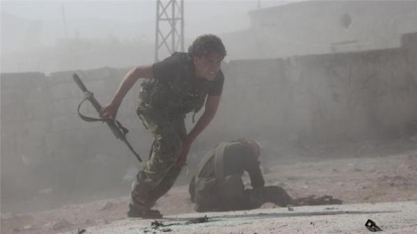 An Ahrar al-Sham fighter runs for cover during clashes with Assad loyalists