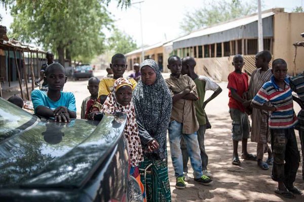 Children stand around a vehicle in Chibok in Borno State north-eastern Nigeria on March 25, 2016. There's not much left of the Government Girls Secondary School in Chibok, northeast Nigeria, where Boko Haram kidnapped 276 teenagers in the dead of night nearly two years ago.