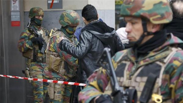 Belgian troops search people entering a subway station following Tuesday's bomb attacks