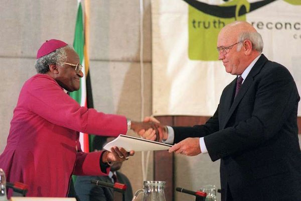 Former South African president F. W. de Klerk (right) handing overs the party's submission to Archbishop Desmond Tutu, head of the Truth and Reconciliation Commission (TRC) during the National Party's submission before the TRC in Cape Town on August 21, 1996.