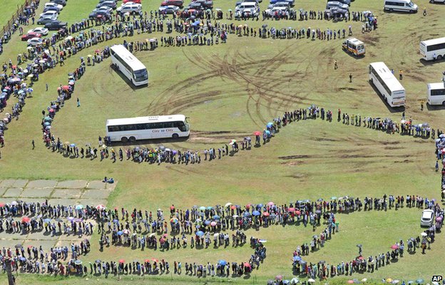Long queues of mourners wait catch a bus to view the body of ex-President Nelson Mandela, a scene reminiscent of that in 1994 when voters queued in Soweto