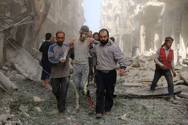 Syrians help a wounded youth following an air strike on the Fardous rebel held neighbourhood of the northern Syrian city of Aleppo on April 26, 2016.
