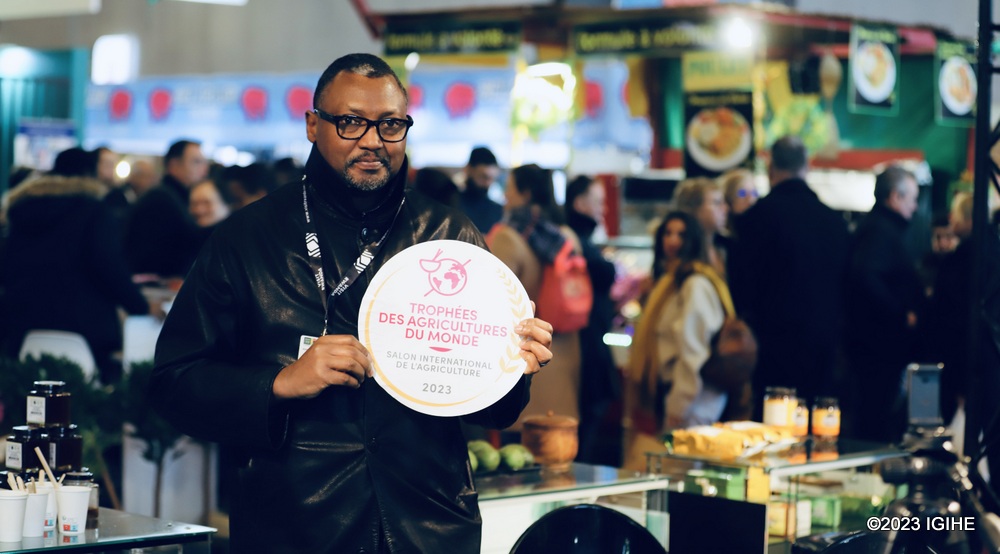 IGIHE journalist holding the award presented to Rwanda at the trade show in France. 
