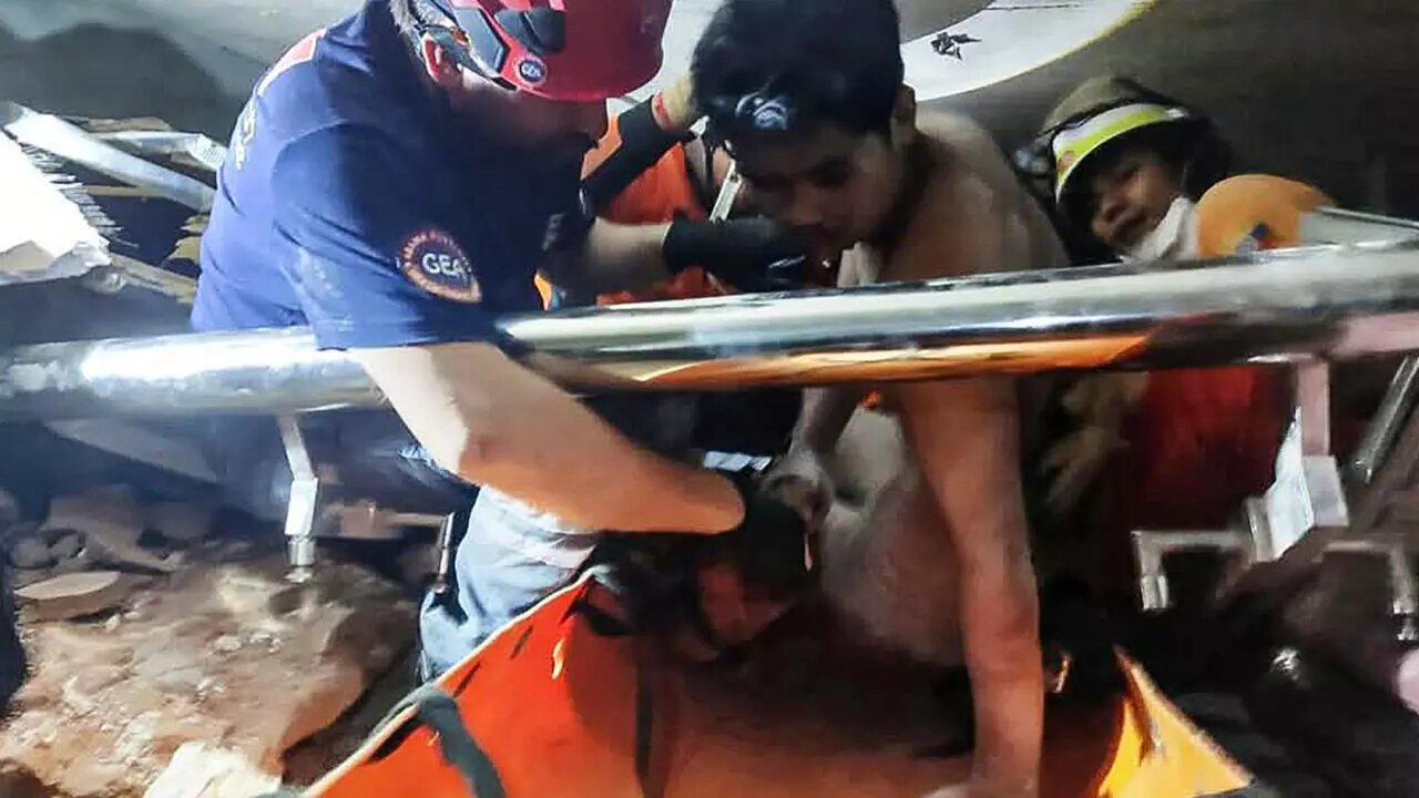 A joint team of Myanmar and Turkish rescuers pull a man alive from the rubble of a hotel in the capital Naypyidaw, five days after a major earthquake.