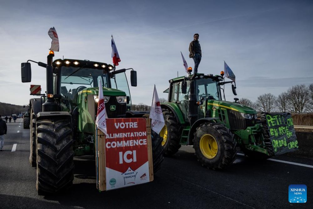 French farmers block a highway with their tractors during a protest in Longvilliers, near Paris, France, on Jan. 29, 2024. French farmers blocked motorways around Paris on Monday afternoon as they continued protesting against rising prices, red tape and "unfair competition" from other countries. (Photo by Aurelien Morissard/Xinhua)