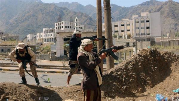 Fighters loyal to the Saudi-backed Yemeni government take positions during clashes with Houthi rebels in Taiz