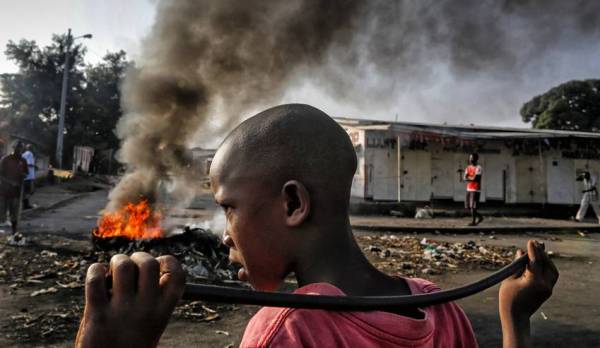 A young Burundian boy tries to cover himself as police officers beat him after dispersing protesters by firing shots during an anti-government demonstration against President Pierre Nkurunziza's bid for a third term in the capital Bujumbura, Burundi, 26 May 2015.
