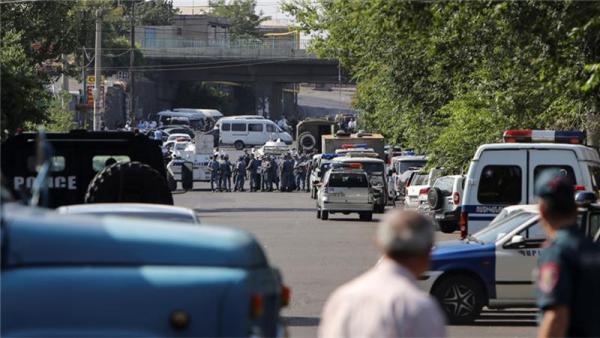 Policemen block a street after a group of armed men seized a police station along with an unknown number of hostages