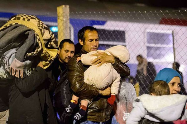 Migrants and refugees walk towards a refugee center in Sentilj, Slovenia, after arriving by train on November 4, 2015.