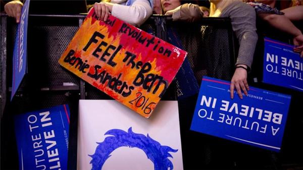 People hold signs in support of Democratic presidential candidate Bernie Sanders