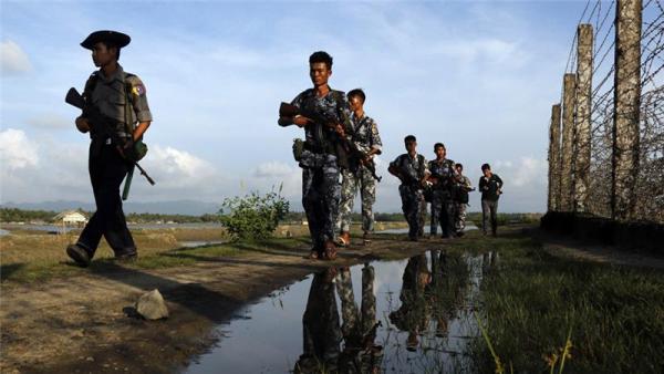 Myanmar police patrol along the border fence between Myanmar and Bangladesh in Maungdaw district