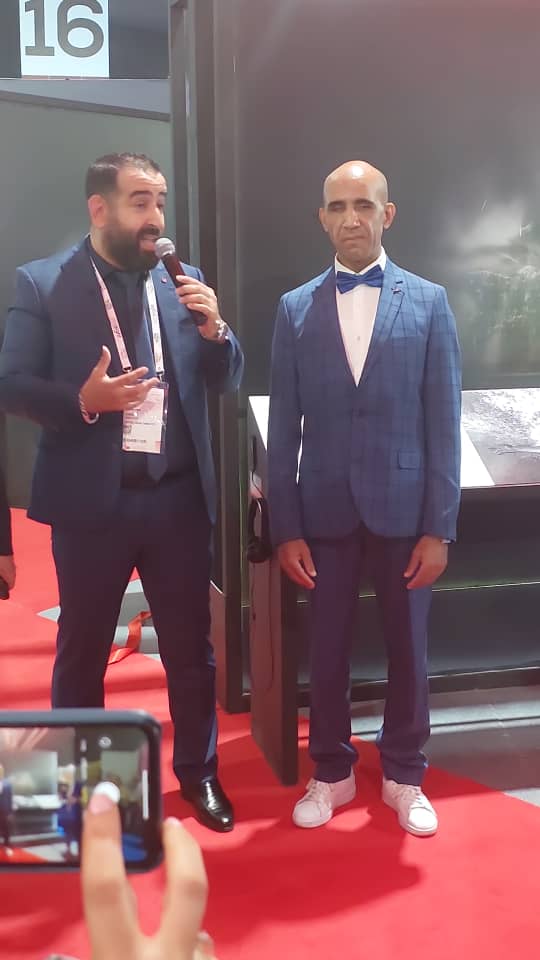 Hamid Nabil (left) , who is visually impaired, poses for a photo at the exhibition site.