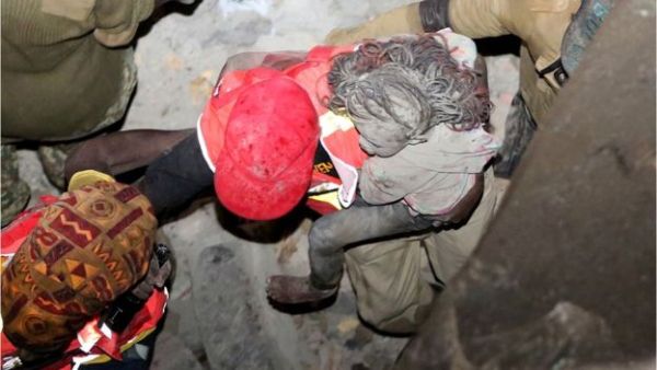 A girl is rescued from the collapsed building - at least five of the dead are reported to be children