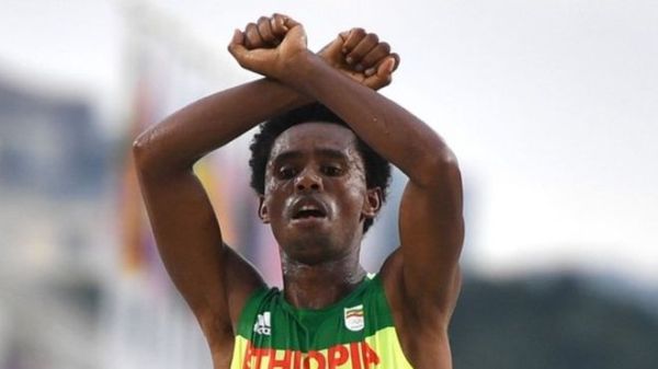 Feyisa Lilesa made the gesture as he crossed the line and again at a press conference
