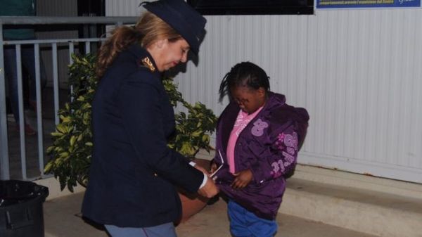 A police handout picture shows officer Maria Volpe taking care of Oumoh, whose face has been blurred