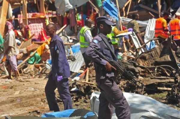Security officers at the scene of the suicide car bomb, which hit a market in southern Mogadishu