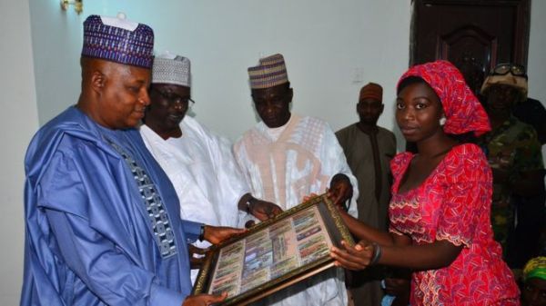 Glory Dama, one of the released girls, presented a thank-you gift to state governor Kashim Shettima