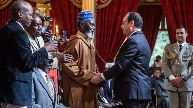 French President Francois Hollande (centre right) shakes the hand of one of the veterans