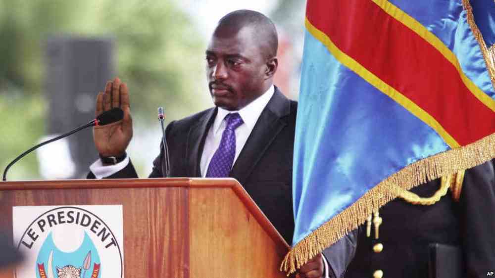 Incumbent Congo President Joseph Kabila holds the Congolese flag as he takes the oath of office as he is sworn in for another term, in Kinshasa, Democratic Republic of Congo.