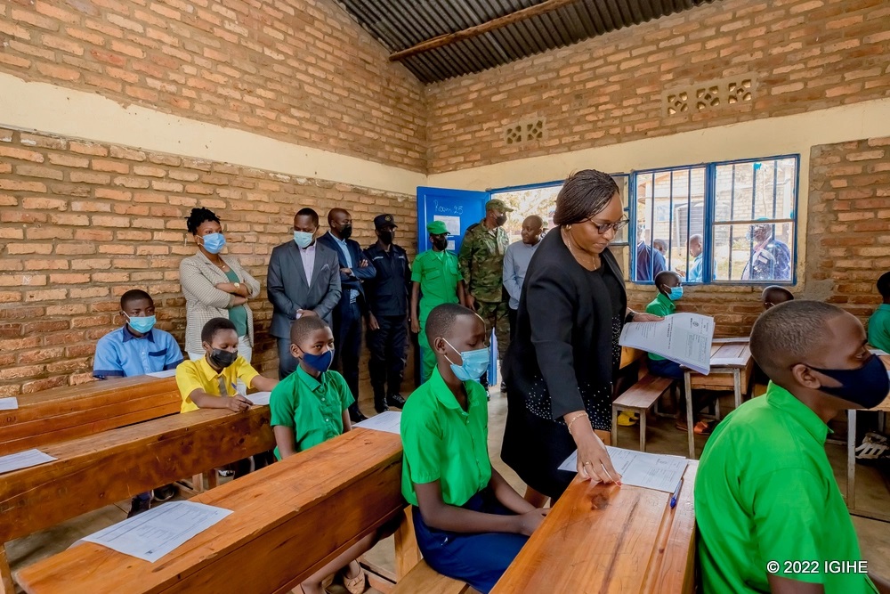 Minister Uwamariya offering exam papers to primary finalists as she officiated the start of national exams.  