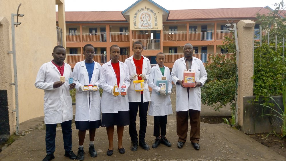Students and teachers holding samples of produced soaps. 