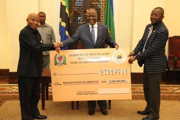 PRESIDENT John Magufuli receives a dummy cheque for 12bn/- from the Chairman of the National Electoral Commission (NEC), Judge (Retired) Damian Lubuva, at the State House in Dar es Salaam, being savings from last year’s general election expenses. Right is Director of Elections, Mr Ramadhani Kailima. (Photo by State House) PRESIDENT John Magufuli receives a dummy cheque for 12bn/- from the Chairman of the National Electoral Commission (NEC), Judge (Retired) Damian Lubuva, at the State House in Dar es Salaam, being savings from last year’s general election expenses. Right is Director of Elections, Mr Ramadhani Kailima.