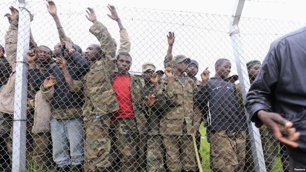 Congolese M23 rebel fighters gather inside an enclosure after surrendering to Uganda's government at Rugwerero village in Kisoro district, about 490 km west of Kampala, Nov. 8, 2013.