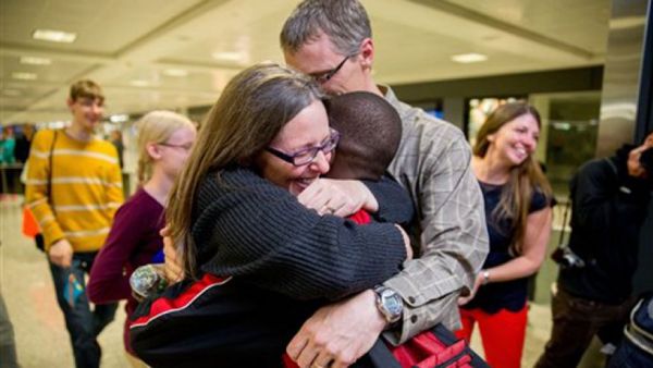 ov. 11, 2015: Jennifer and Eric Sands of Illinois hug their adopted son Issaac, 12, as he arrives from the Congo at Dulles International Airport.