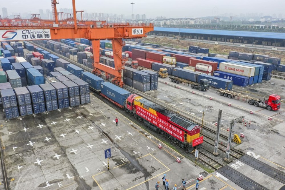Aerial photo taken on June 23, 2022 shows a cargo train, which marks the 10,000th trip made by China-Europe freight trains operated by the China-Europe Railway Express (Chongqing), waiting for departure at Tuanjie Village Central Railway Station in Chongqing, southwest China. (Xinhua/Huang Wei)