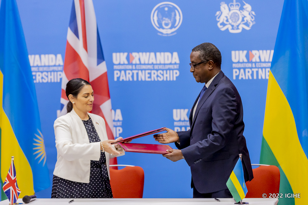 Minister Biruta and UK Home Secretary Priti Patel exchanging documents after signing migration and economic development partnership in Kigali. 