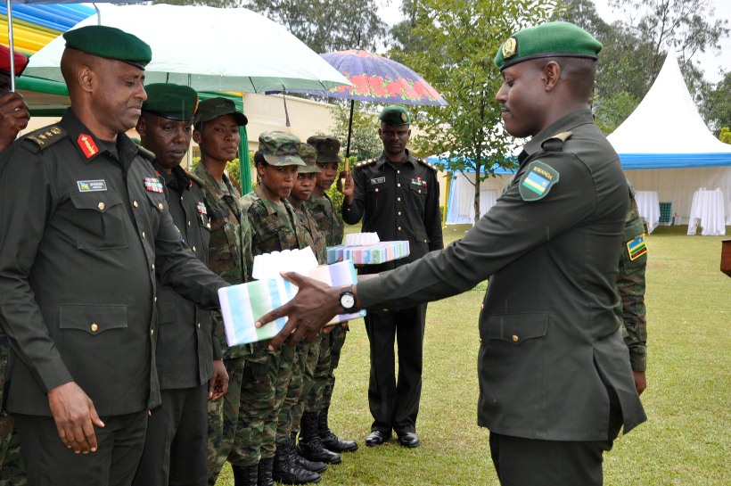 Maj Gen Kazura and Chief Instructor Col Majyambere (2nd right) presenting a gift to one of the best students