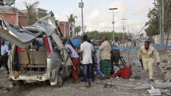 A Somali policeman runs through the wreckage outside the Sahafi Hotel in Mogadishu, Somalia, Nov. 1, 2015.