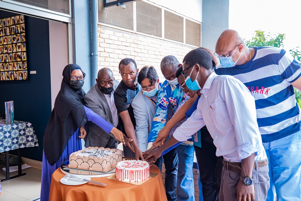 Participants cutting a cake in celebration of achievements.