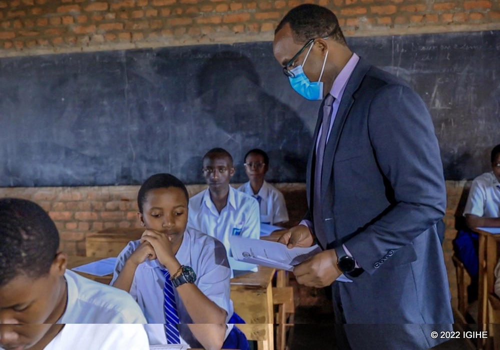 Twagirayezu handing papers to finalists as he officiated the start of national exams. 