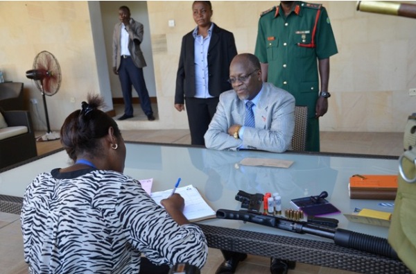 PRESIDENT John Magufuli registers details of firearms in his care before Assistant Inspector of Police Neema Laizer in Dar es Salaam on Monday. (Photo by State House)