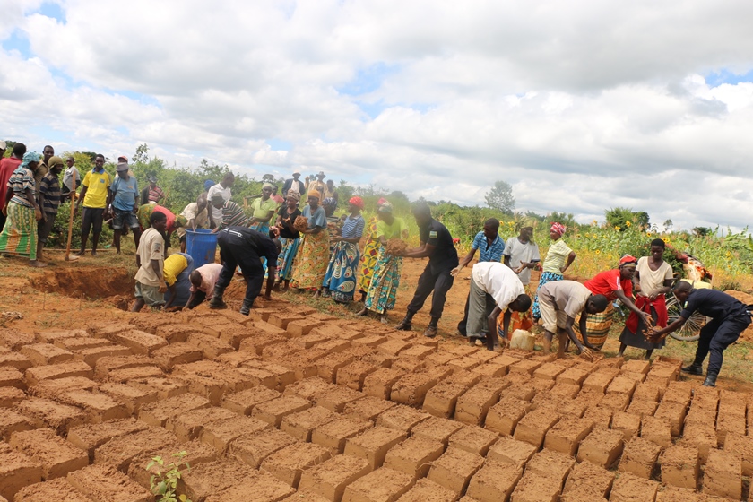Residents and Police laying bricks for the construction of 38 toilets to improve sanitation.