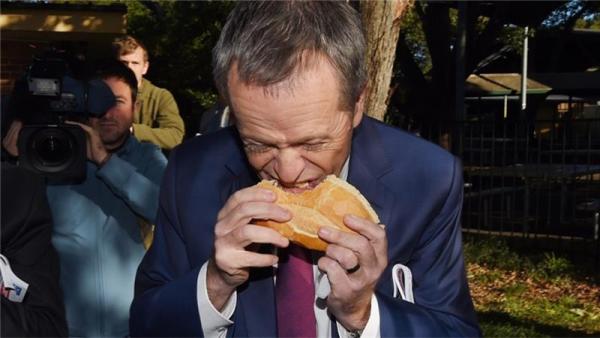 Leader of the Opposition Bill Shorten sticks with tradition and eats a sausage sandwich at the polling station