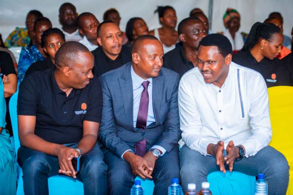 The Country Manager of Serena Hotel, Daniel Sambai (in the middle) chatting with Emmy Ngabonziza (right) at the event.  