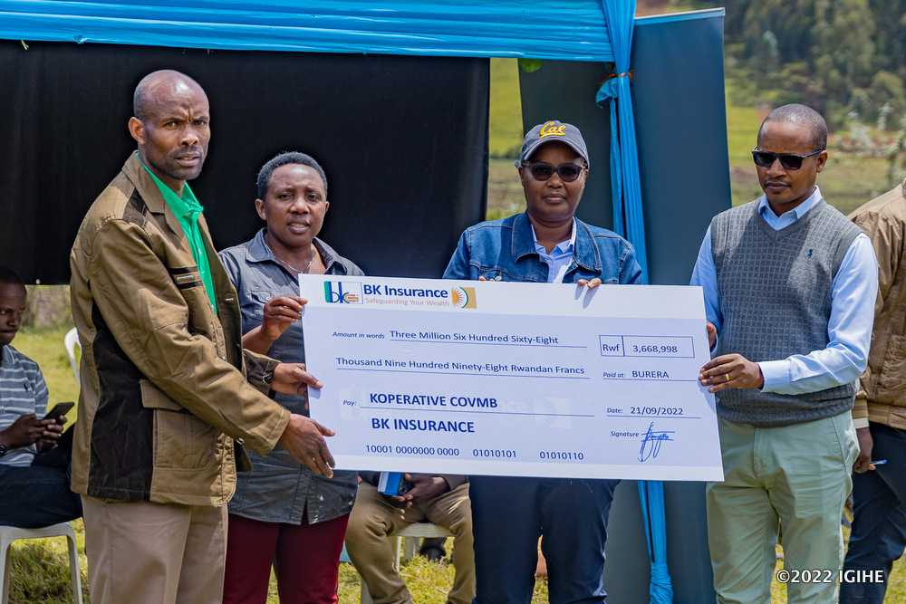 Bahizi (right), Minisitiri Mukeshimana and the Mayor of Burera District handing over a dummy cheque to the president of COVBM cooperative.